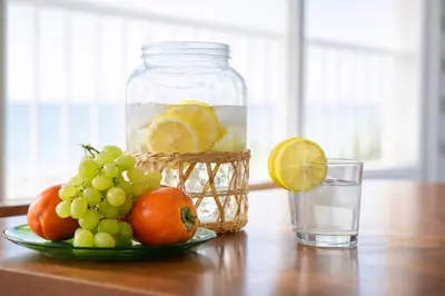 a plate of fruit on a table with a glass of water at Apartamento en primera línea de playa con vistas al mar in Mareny Barraquetas