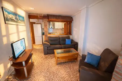 a living room with a couch and a table at Apartamento en primera línea de playa con vistas al mar in Mareny Barraquetas