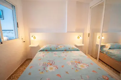 a bedroom with a bed with a floral bedspread at Apartamento en primera línea de playa con vistas al mar in Mareny Barraquetas