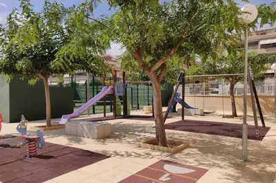 a park with a playground with a slide and trees at Apartamento nuevo playa de Canet de Berenguer WIFI in Canet de Berenguer