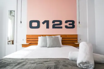 a bedroom with a large white bed with a sign on the wall at Torres de Serrano Apartment in Valencia