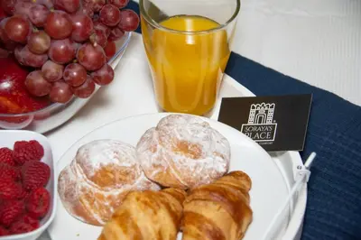 a white plate with pastries and fruit on a table at Soraya's Place - Chopín 5 in Valencia