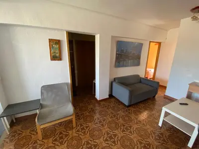 a living room with a couch and a chair at Piso cerca de la playa - Act. Mauri 1B in Valencia