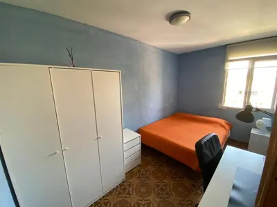a bedroom with a bed and a cabinet and a window at Piso cerca de la playa - Act. Mauri 1B in Valencia