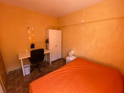 a small bedroom with an orange bed and a desk at Piso cerca de la playa - Act. Mauri 1B in Valencia