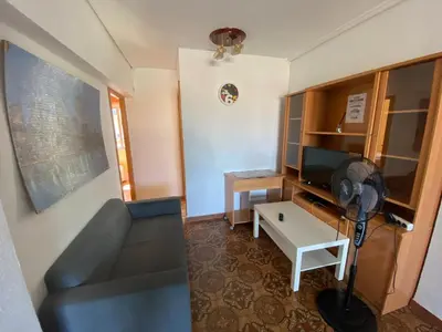 a small room with a fan and a desk with a television at Piso cerca de la playa - Act. Mauri 1B in Valencia