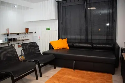 a living room with a black couch and two chairs at Soraya's Place - Chopín 2 in Valencia