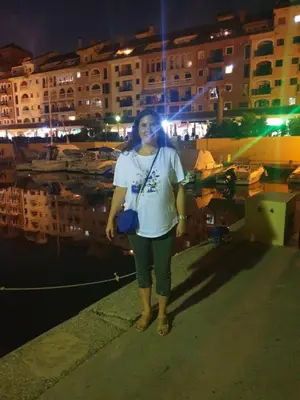 a woman standing next to a marina at night at Alquiler Universidades Malvarrosa Playa Maritim Valencia Solo para familias con niños in Valencia