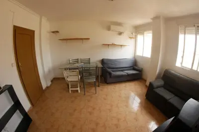 a living room with a couch and a table and chairs at apartemento ideal grupo y familia climatisacion y cerca playa . mongrell in Valencia