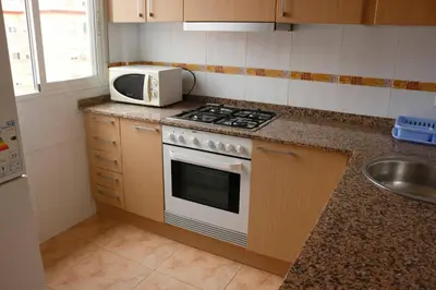 a kitchen with a stove and a microwave on the counter at apartemento ideal grupo y familia climatisacion y cerca playa . mongrell in Valencia