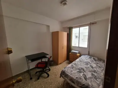 a bedroom with a bed and a desk and a table at Apartemento grupo amigo o familias : blasco ibanez C in Valencia