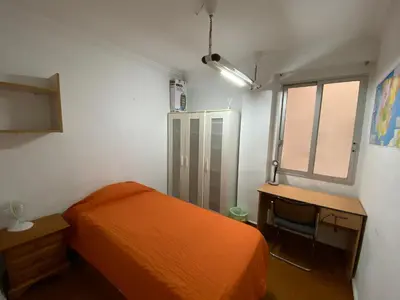 a bedroom with a bed and a desk and a window at piso para jovenes familia cerca playa y centro . BLASCO IBANEZ A in Valencia