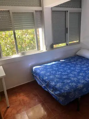 a bed in a room with two windows at apartemento nuevo cerca playa para familia o amigos . isidro in Valencia
