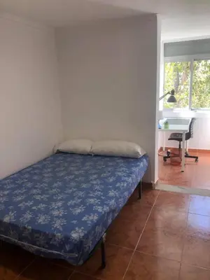 a bedroom with a bed and a desk in a room at apartemento nuevo cerca playa para familia o amigos . isidro in Valencia