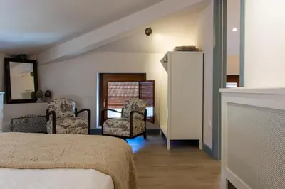 a bedroom with a bed and two chairs and a fireplace at Los Canilleros in Requena