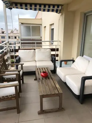 a balcony with white couches and a wooden table at Apartamento de playa Valmar - Beachfront exclusive residential in El Perellonet
