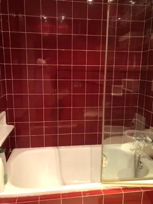 a red tiled bathroom with a bath tub with a shower at Apartamento de playa Valmar - Beachfront exclusive residential in El Perellonet