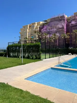 a swimming pool in front of a building at Apartamento de playa Valmar - Beachfront exclusive residential in El Perellonet