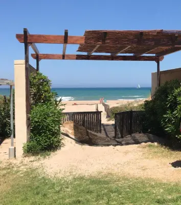 a wooden pergola on a beach with the ocean at Apartamento de playa Valmar - Beachfront exclusive residential in El Perellonet