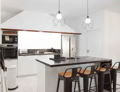 a kitchen with a counter with chairs and a sink at Villa Conchin Casa junto a Parque Natural in Alberique