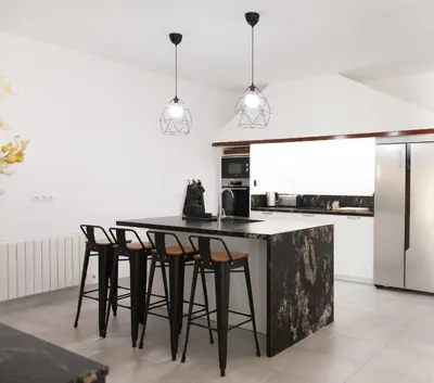 a kitchen with a black counter and stools at Villa Conchin Casa junto a Parque Natural in Alberique