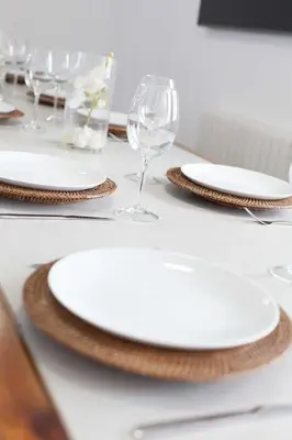 a table with white plates and wine glasses on it at Villa Conchin Casa junto a Parque Natural in Alberique