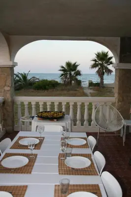 a table and chairs on a balcony with the ocean at Beach House Villa Roca in Cullera