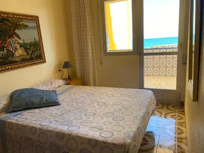 a bedroom with a bed and a window at 1era linea de playa VILLA MARGARET Cullera Marenyet in Cullera