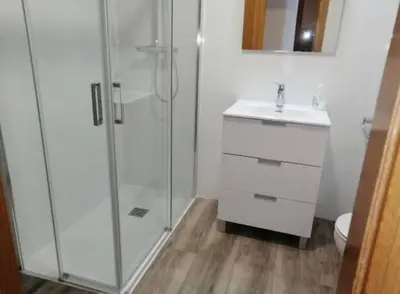 a white bathroom with a shower and a sink at Precioso atico en pleno centro de Valencia in Valencia