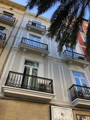 a large white building with balconies and a palm tree at Precioso atico en pleno centro de Valencia in Valencia