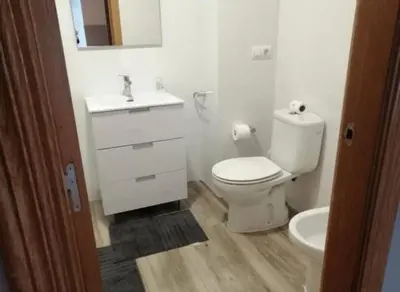 a white bathroom with a toilet and a sink at Precioso atico en pleno centro de Valencia in Valencia