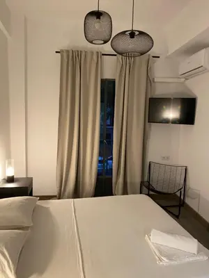 a bedroom with a bed and two pendant lights at Shanti Rooms in Valencia