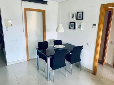 a dining room with a black table and chairs at NON STRESS Ático Dúplex con vistas al MAR in Valencia