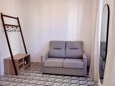 a living room with a chair and a mirror at Hotel 19-30 Valencia in Valencia