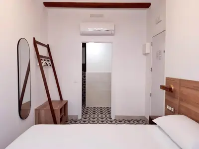 a white room with a hallway with a bed and a door at Hotel 19-30 Valencia in Valencia