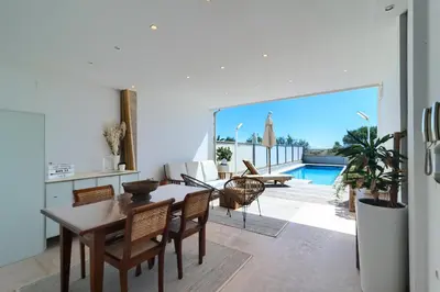 a kitchen and living room with a table and chairs at Casa frente al mar con piscina privada in Sagunto
