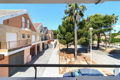 a view from the balcony of a building with a palm tree at Casa frente al mar con piscina privada in Sagunto