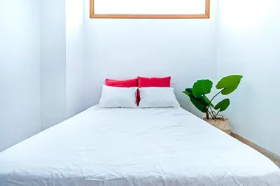 a bedroom with a white bed with red pillows at Design, beach and city center in Valencia