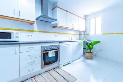 a kitchen with white cabinets and a stove top oven at Design, beach and city center in Valencia