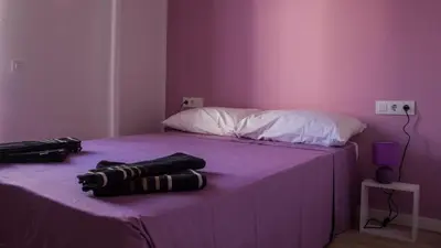 a bedroom with a purple bed with two towels on it at Colors Rooms in Valencia