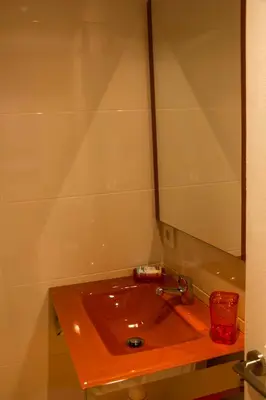 a bathroom with a red sink and a mirror at Colors Rooms in Valencia