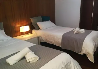 a hotel room with two beds with towels on them at Pensión Les Eres in Puebla de Vallbona