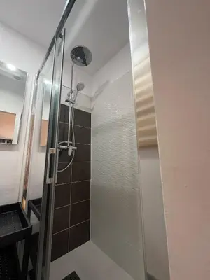 a shower with a glass door in a bathroom at Pensión Les Eres in Puebla de Vallbona