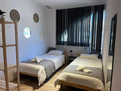 a bedroom with two beds and a ladder at Pensión Les Eres in Puebla de Vallbona