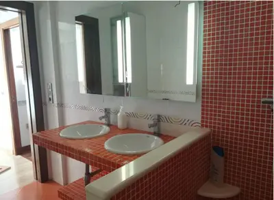 a bathroom with two sinks and a large mirror at Pensión Les Eres in Puebla de Vallbona