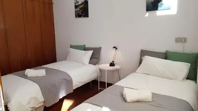 a room with two twin beds and a table at Pensión Les Eres in Puebla de Vallbona
