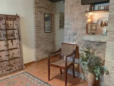 a chair in a room with a stone wall at Ca'n Josep in Segorbe