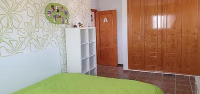 a bedroom with a green bed and two wooden doors at Maravisa in Puebla de Vallbona