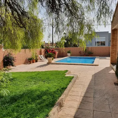 a backyard with a swimming pool and green grass at Maravisa in Puebla de Vallbona