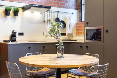 a wooden table with chairs and a vase with flowers at ART LOFTS Valencia by Benisur in Valencia
